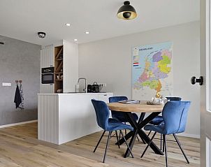 Stijlvolle eetruimte in Vakantiehuis in Een, Noord Drenthe, met ronde tafel en kaart van Nederland aan de muur.