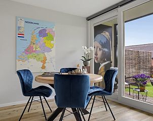 Eetkamer in Vakantiehuis in Een, Noord Drenthe, met uitzicht op de tuin en kunst aan de muur.