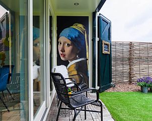 Charmante veranda van Vakantiehuis in Een, Noord Drenthe, met kunstzinnig detail op de muur.