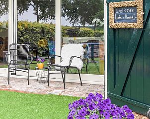 Welkom bij Vakantiehuis in Een, Drenthe, met gezellige zithoek en kleurrijke bloemen.