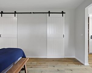 Slaapkamer met schuifdeuren in Vakantiehuis in Een, Noord Drenthe, voor een open en ruimtelijk gevoel.