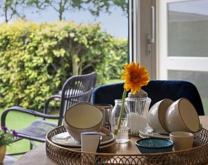 Gezellige ontbijthoek in Vakantiehuis in Een, Drenthe, met uitzicht op de groene tuin.