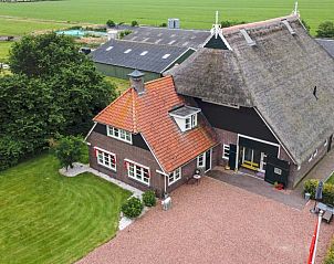 Traditionele boerderij bij Vakantiehuis in Een, Noord Drenthe, met rieten dak en groene omgeving.