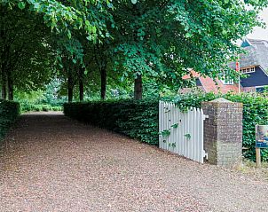 Gezellige toegangspoort naar Vakantiehuisje in Een, Noord Drenthe, met groene omheining en bord.