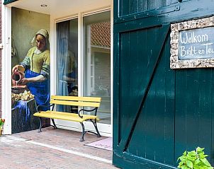 Charmante entree van Vakantiehuisje in Een, Noord Drenthe, met uitnodigende bank en decoratieve kunst.