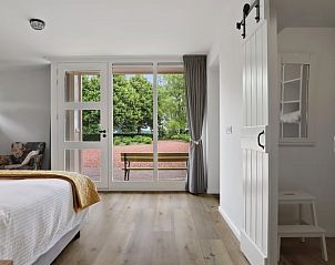 Lichte slaapkamer in Vakantiehuisje in Een, Noord Drenthe, met uitzicht op de tuin en comfortabele inrichting.