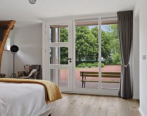 Comfortabele zithoek in Vakantiehuisje in Een, Noord Drenthe, met gezellige stoelen en houten details.