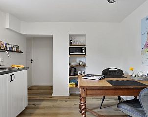 Gezellige eetruimte in Vakantiehuisje in Een, Noord Drenthe, met kaart van Nederland en houten meubels.