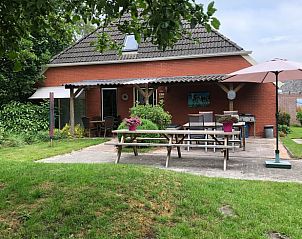 Veranda van Huisje in Spijkerboor, Noord Drenthe, met gezellige zithoek en parasol.