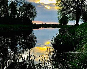 Prachtige zonsondergang bij Huisje in Spijkerboor, Noord Drenthe, weerspiegeld in het water.
