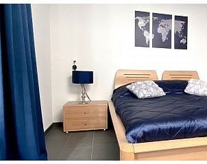 Comfortabele slaapkamer in bungalow Rendez vous, Zuidlaren, Noord Drenthe, met houten meubels en blauwe accenten.