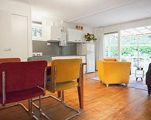 Gezellige woonkamer van Huisje in Zuidlaren met kleurrijke stoelen, gelegen in Noord Drenthe, Drenthe.