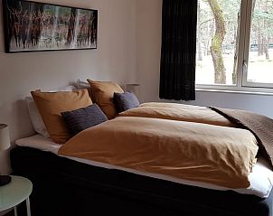 Slaapkamer in Vakantiehuisje in Norg, Noord Drenthe met comfortabel bed en boszicht.