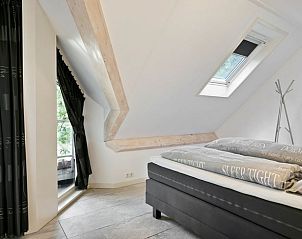 Ruime slaapkamer in Vakantiehuisje in Norg, Drenthe met uitzicht op de tuin.