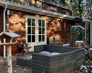 Gezellige buitenruimte van Vakantiehuisje in Norg, Noord Drenthe, met zitgedeelte en vogelhuisje.