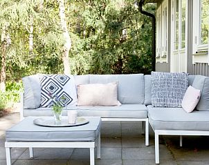 Terrasse mit bequemen Sitzgelegenheiten im Ferienhaus in Norg, Nord-Drenthe, umgeben von viel Grn.