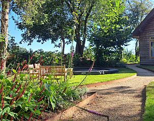 Trampoline in de tuin van DG588 vakantiehuis in Midlaren, Drenthe, omgeven door groen en zitmeubilair.
