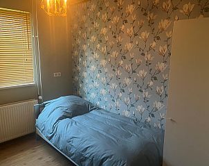 Lichte entree van vakantiehuis DG1879 in Borger, Noord Drenthe met tegelvloer en spiegel.