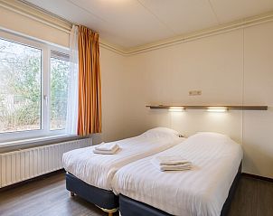 Slaapkamer in bungalow H6A in Borger, Drenthe met twee comfortabele bedden en een groot raam.