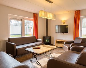 Gezellige woonkamer van bungalow H10A in Borger, Noord Drenthe met comfortabele banken en een moderne houtkachel.