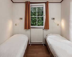 Tweede slaapkamer in chalet LU6, Borger, Drenthe met twee eenpersoonsbedden en uitzicht op de tuin.