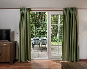 Gezellige slaapkamer in chalet LU4K, Borger, Drenthe met twee eenpersoonsbedden en uitzicht op groene natuur.