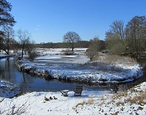 Winterlandschap bij Vakantiehuisje in Schipborg, Drenthe met besneeuwde rivieroevers.