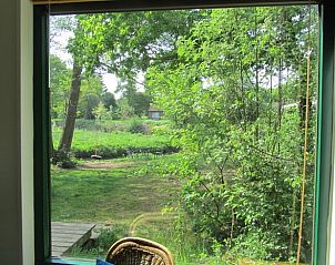 Groot raam met uitzicht op tuin in vakantiehuisje in Schipborg, Drenthe.