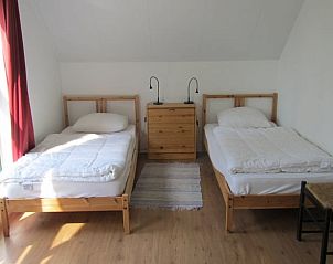 Tweepersoons slaapkamer in vakantiehuisje in Schipborg, Drenthe met houten bedden.