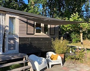 Schaduwrijke zithoek bij Huisje in Schipborg, vakantieaccommodatie in Drenthe, perfect voor warme dagen.