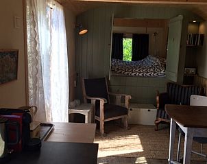 Lichte woonkamer van Huisje in Schipborg, vakantiehuis in Noord Drenthe, met uitzicht op de tuin.