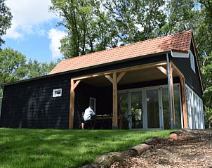 Zijaanzicht van Vakantiehuisje in Schipborg, Noord Drenthe, met zonnig terras en grasveld.