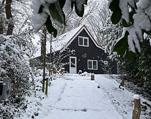 Vakantiehuisje in Schipborg, Noord Drenthe, bedekt met sneeuw in een winterlandschap.