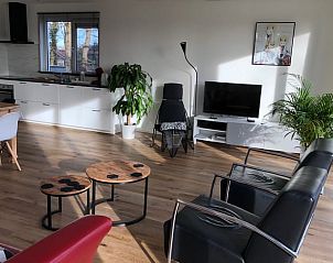Moderne woonkamer van Vakantiehuisje in Schipborg, Noord Drenthe, met open keuken en zithoek.