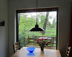 Eettafel bij het raam in DG577 vakantiehuis, Schipborg, Drenthe met uitzicht op de groene natuur.