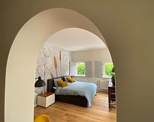 Gezellige binnenruimte van Huisje in Tynaarlo, Noord Drenthe, met een boogdoorgang naar de slaapkamer.