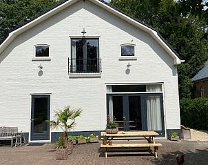 Vooraanzicht van Huisje in Tynaarlo, Noord Drenthe, met een ruim terras en gezellige zitplekken.