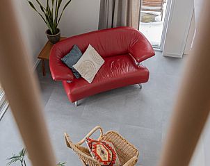 Stijlvolle woonkamer met rode bank in Vakantiehuis in Tynaarlo, Drenthe.