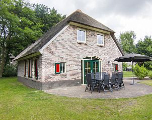 Terras met tuinmeubilair en parasol bij Het Land van Bartje, 8-persoons vakantiehuis in Ees, Noord Drenthe.