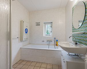 Moderne badkamer met bad en douche in Het Land van Bartje, 8-persoons kinderboerderij in Ees, Drenthe.