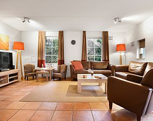 Eethoek in Het Land van Bartje 10-persoons kinderboerderij, Ees, Drenthe, met moderne stoelen en tafel.