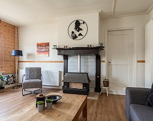 Ruime woonkamer in DG984 vakantiehuis, Vries, Drenthe, met televisie en comfortabele stoelen.