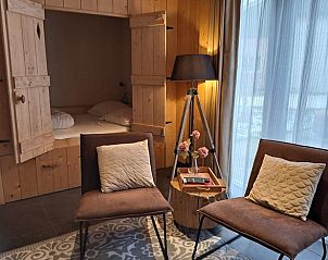 Knusse zithoek in Vakantiehuis in Zeegse, Drenthe met comfortabele stoelen en houten interieur.