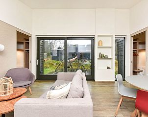 Woonkamer van vakantiehuis in Zeegse met uitzicht op terras en natuur.