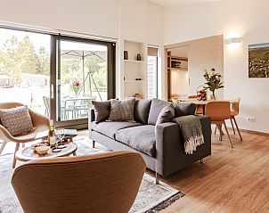 Lichte en ruime woonkamer in Huisje in Zeegse, een vakantiewoning in Drenthe, met toegang tot het terras.