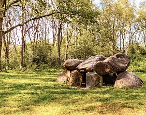 Historische hunebedden in de buurt van Huisje in Zeegse, een vakantiewoning in Drenthe, omringd door groen.