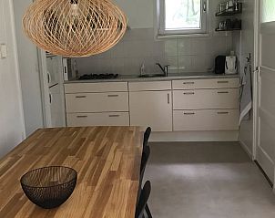 Functionele keuken in Huisje in Steenbergen, vakantiehuis in Noord Drenthe met houten eettafel en moderne voorzieningen.