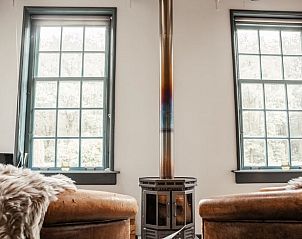 Houtkachel in Vakantiehuis in Veenhuizen, Noord Drenthe creert een warme sfeer in de woonkamer.