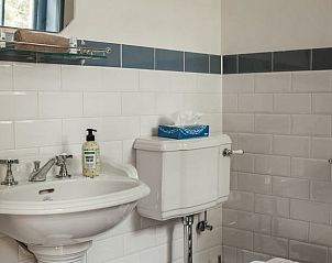 Stijlvolle badkamer in Vakantiehuisje in Veenhuizen, Drenthe, met klassieke wastafel en tegelwerk.