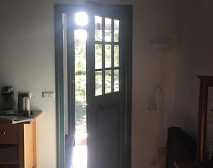 Zicht vanuit de entree van Vakantiehuisje in Veenhuizen, Noord Drenthe, op de groene tuin.